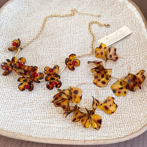 Close-up of leopard print resin petals and red beads on gold vintage jewelry set