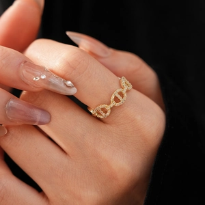 Close-up of gold-plated pig nose ring with pavé-set zircons on a model's finger