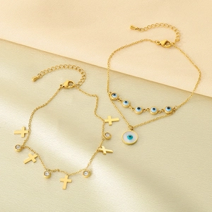 Détails de chevillières en acier doré avec pendentifs mauvais œil et croix