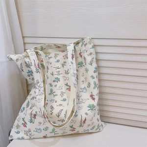 Close-up of floral and animal printed canvas tote bag with forest pattern details