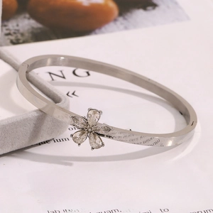 Macro detail of silver flower bracelet with sparkling zircons on a soft gray display cushion