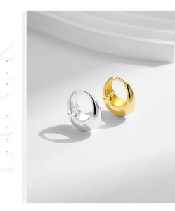 Macro detail of thick S925 sterling silver hoop earrings in gold and silver mirror finish