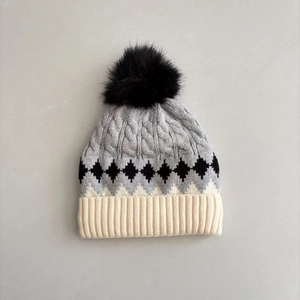 Winter knitted hat for toddlers featuring argyle pattern and a faux fur pompom detail
