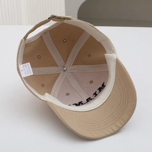 Internal view of khaki cotton baseball cap showing stitching and 100% cotton label