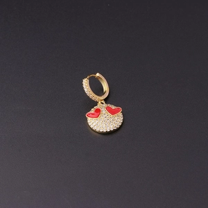 Detailed close-up of a gold-plated hoop earring featuring red enamel hearts and zircons