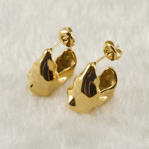Macro shot of gold-plated stainless steel earrings with irregular geometric texture