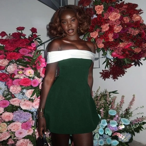 Detail of off-shoulder green mini dress with white neckline contrast and matte texture