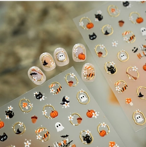 Detail of Halloween nail decals with gold pumpkin, ghost and black cat designs