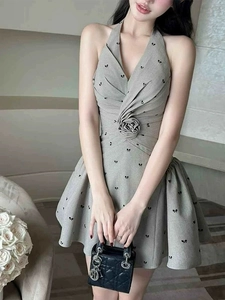 Detail of grey halter dress with 3D floral accent and black butterfly print pattern