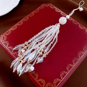 Detail of luxury crystal tassel phone charm with heart pendants on red display box