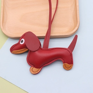 Detail of dachshund leather pendant featuring fine lychee grain texture and red-orange finish