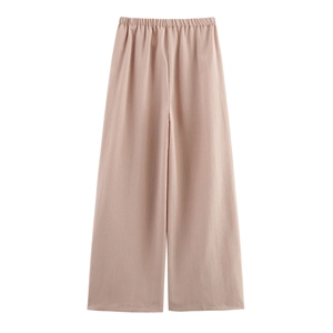 Détail du pantalon large rose clair avec taille élastique et texture de tissu plissé vertical