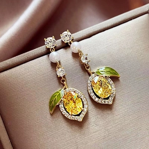 Exquisite lemon stud earrings with yellow gems, green leaves and pearls in a jewelry box