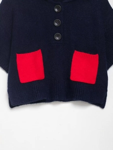 Close-up of navy knit sweater featuring high-quality fiber texture and red contrast pocket