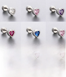 Macro view of heart-shaped zircon stud earrings with various crystal colors and steel base