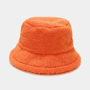 Close-up of bright orange plush bucket hat showing thick lamb wool texture and fabric