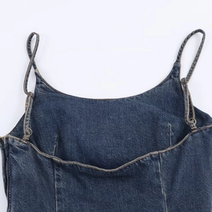 Detail of dark blue denim midi dress with contrast yellow stitching and adjustable metal buckles