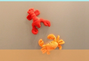 Detail view of plush cartoon red lobster and orange crab ocean animal magnets