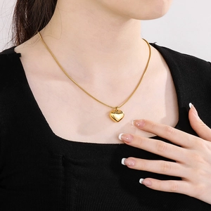 Collier mode avec pendentif cœur évidé doré sur chaîne serpent fine porté par un mannequin