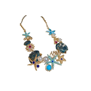 Gold ocean necklace with blue starfish, shells and coral pendants on white background