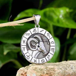 Vintage stainless steel zodiac necklace featuring a detailed Aries ram head pendant on rock