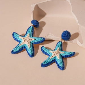 Orecchini a stella marina in rafia intrecciata blu e crema, vista a 45 gradi