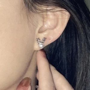 Elegant silver deer antler pearl stud earrings worn for a festive minimalist look