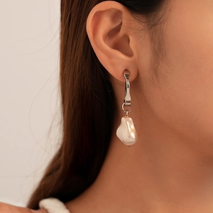 Gros plan détaillé de boucles d'oreilles en perles baroques irrégulières avec anneaux