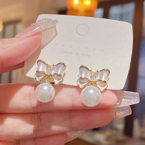 Elegant bowknot pearl drop earrings with sparkling crystals and gold finish on silver needles