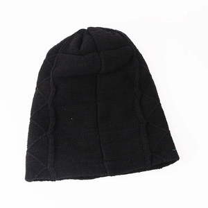 Close-up of black knitted beanie showing cross-stitch texture and warm winter fabric