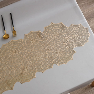 Detailed macro shot of golden spiderweb pattern table runner with hollow out PVC texture