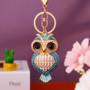 Macro shot of owl keychain with blue enamel inlay and sparkling rhinestones