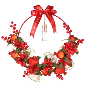Couronne festive de grenades rouges avec feuilles dorées et nœud en soie pour le Nouvel An