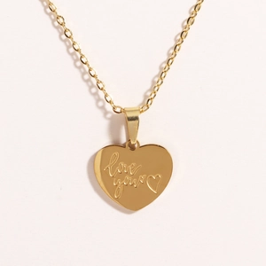 Macro detail of golden titanium steel heart pendant with love you engraving