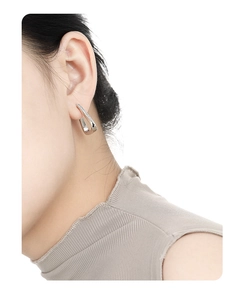 Close-up of minimalist S925 silver triangle earrings with inlaid zircon on a model