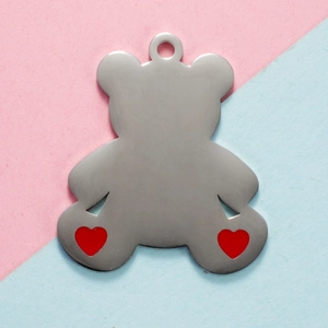 Polished silver bear pendant with red heart details on light pastel background
