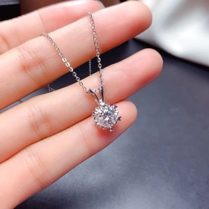 Macro shot of a six-prong sterling silver necklace featuring a brilliant round cut stone