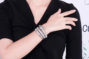 Detail of silver snake wrap bracelet featuring textured scales and diamond-set serpent head