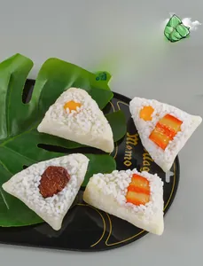 Macro detail of artificial Zongzi models with realistic rice texture on a black tray