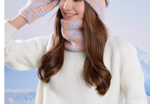 Close-up of knit texture on winter beanie scarf and gloves set with mountain background