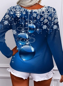 Detail eines blauen Weihnachts-Langarmshirts mit weißen Schneeflocken und Kugelmustern hinten