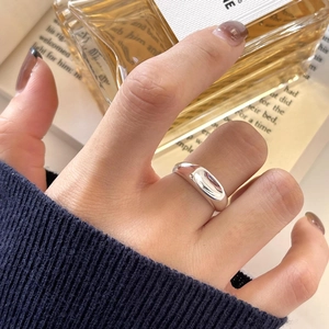 Macro view of wide polished silver ring with a minimalist smooth mirror finish