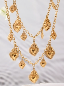 Détails de pendentifs cœurs évidés plaqués or 18k sur un collier à plusieurs rangs