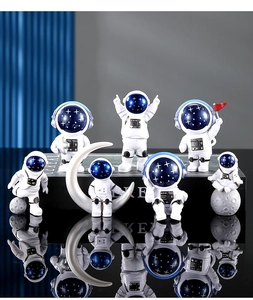 Set di statuette di astronauti in resina con visiere blu su superficie riflettente
