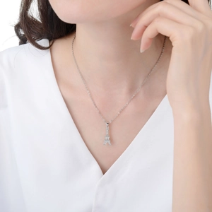 Close-up of sparkling silver Eiffel Tower pendant with CZ stones on a model's neck