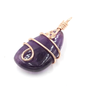 Detailed view of teardrop purple amethyst pendant wrapped in rose gold wire mesh