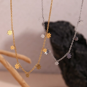 Detailed close-up of 18K gold and silver daisy flower pendants on delicate chains