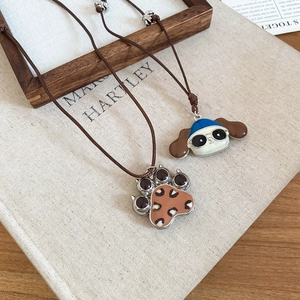 Detail of creative puppy and leopard print heart pendants on brown braided cords