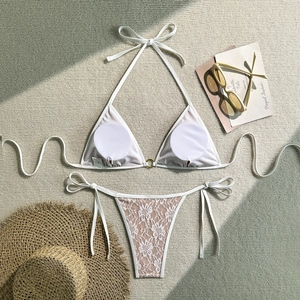 Flat lay of white lace bikini set with gold ring detail and removable pads in size S