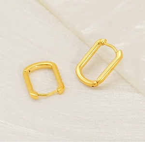 Detailed view of gold plated U-shaped rectangular hoop earrings with a polished finish